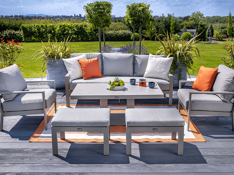 Hartman Rio 3 seat lounge set presented on a rug topped wooden patio with garden in background